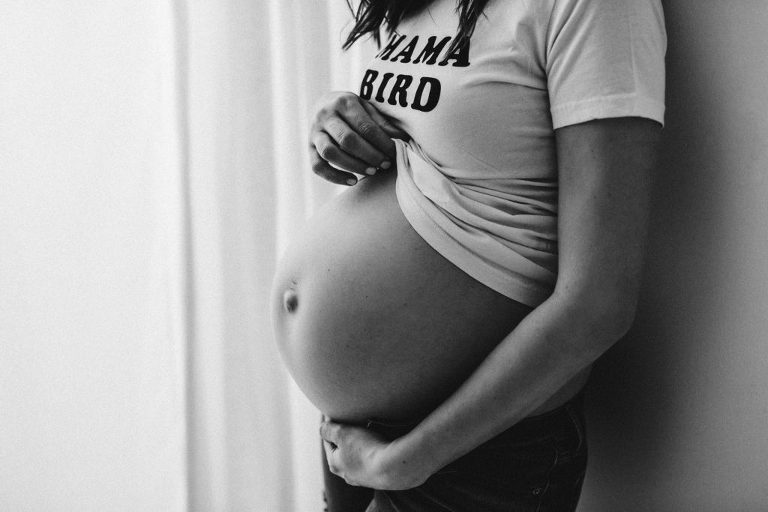 Black and white maternity Baby Bird 7 months pregnant mama standing holding belly