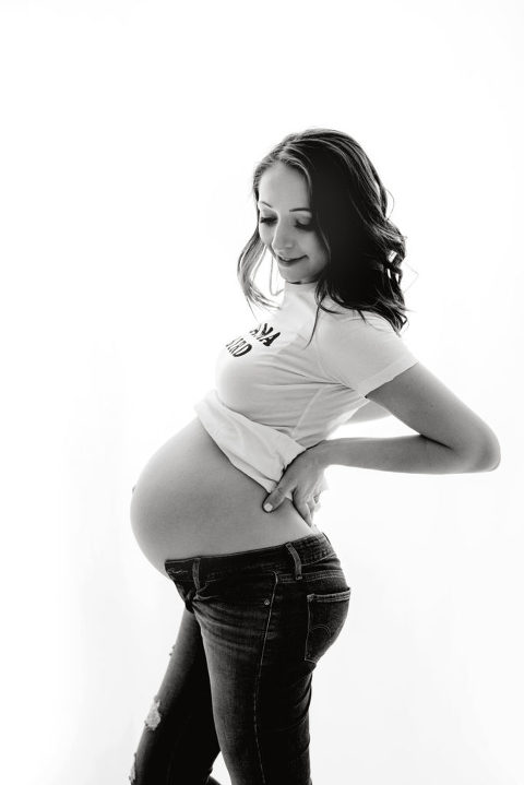 Black and white maternity  7 months pregnant mama standing holding belly