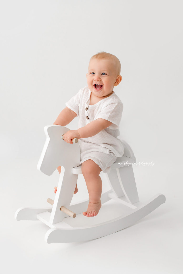 baby boy riding a wooden horse